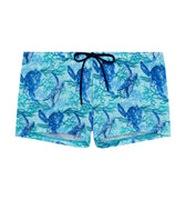 Blue swim shorts with turtle pattern on a white background